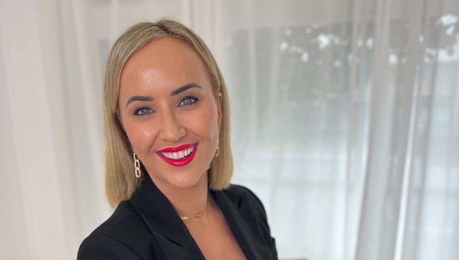 Smiling individual at The GLOW UP Clinic in Albert Park, Melbourne, Victoria, AU with bright red lipstick.