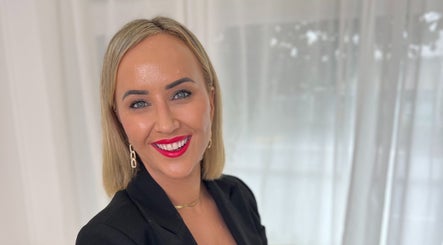 Smiling individual at The GLOW UP Clinic in Albert Park, Melbourne, Victoria, AU with bright red lipstick.