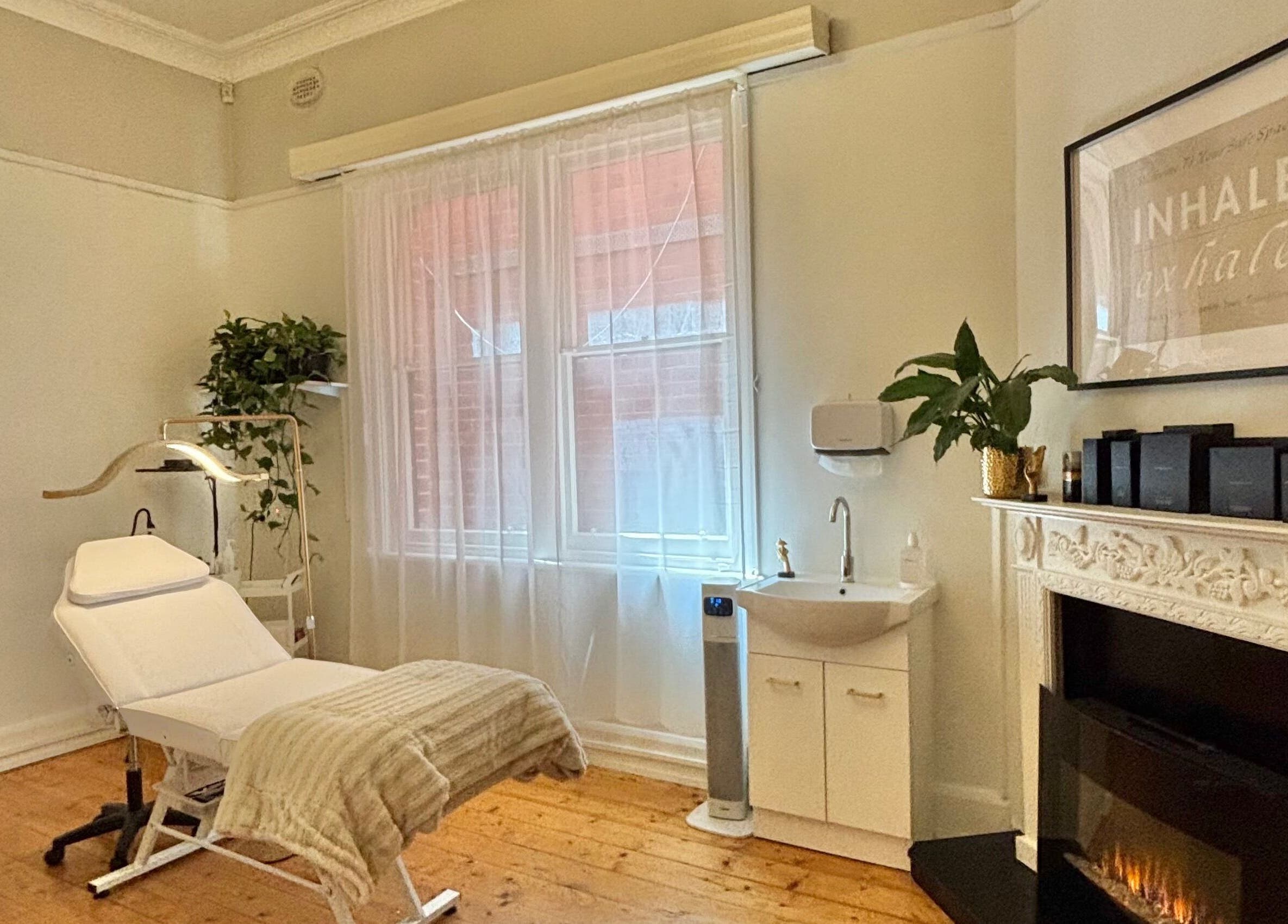 Relaxing treatment room at The GLOW UP Clinic (Elsternwick) in Melbourne, Victoria, AU with a cozy fireplace.