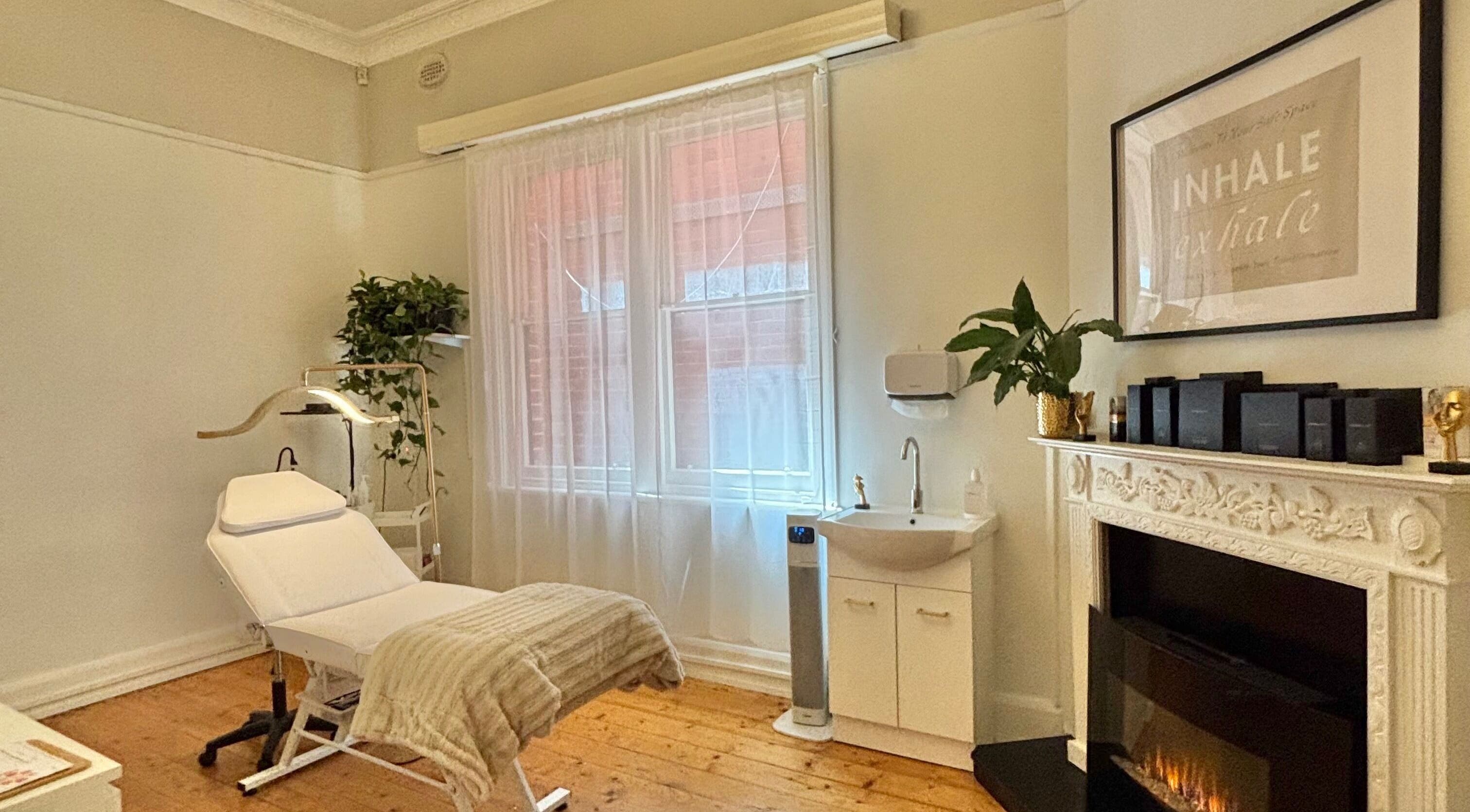 Relaxing treatment room at The GLOW UP Clinic (Elsternwick) in Melbourne, Victoria, AU with a cozy fireplace.