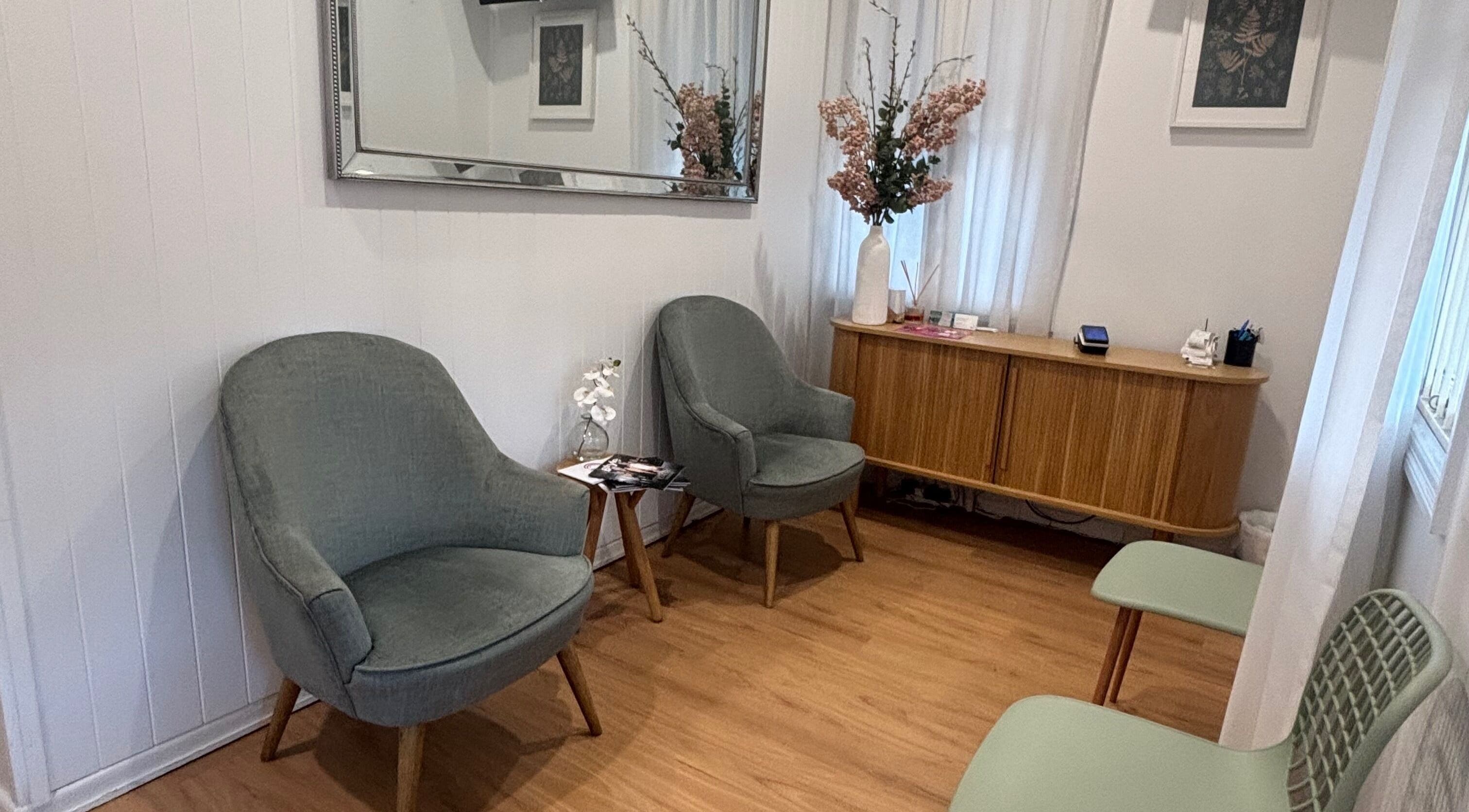 Inviting lounge at The GLOW UP Clinic (Brisbane) in Kangaroo Point, Queensland, AU with chic chairs and a floral touch.