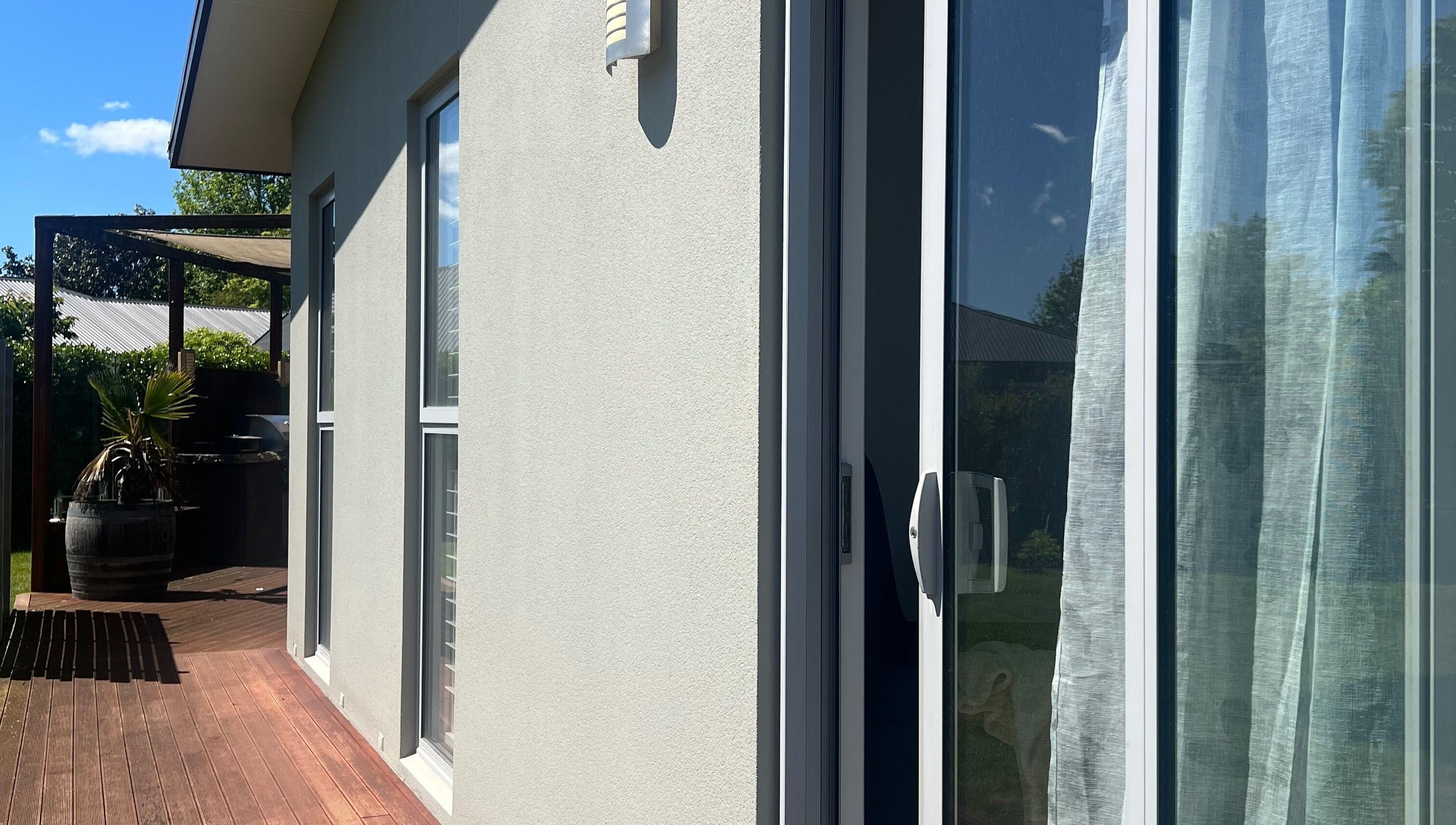 Peaceful patio at HomeGlow Aesthetics, Christchurch, Canterbury Region, NZ, with lush greenery and sunlight.