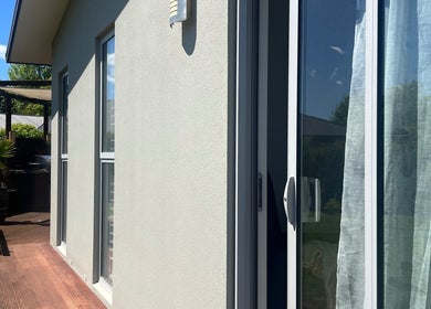 Peaceful patio at HomeGlow Aesthetics, Christchurch, Canterbury Region, NZ, with lush greenery and sunlight.