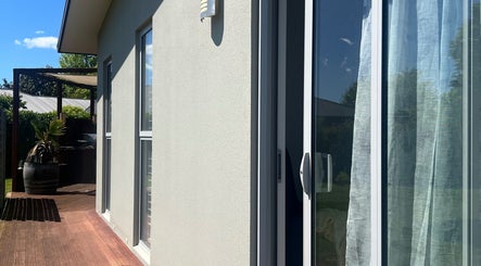 Peaceful patio at HomeGlow Aesthetics, Christchurch, Canterbury Region, NZ, with lush greenery and sunlight.