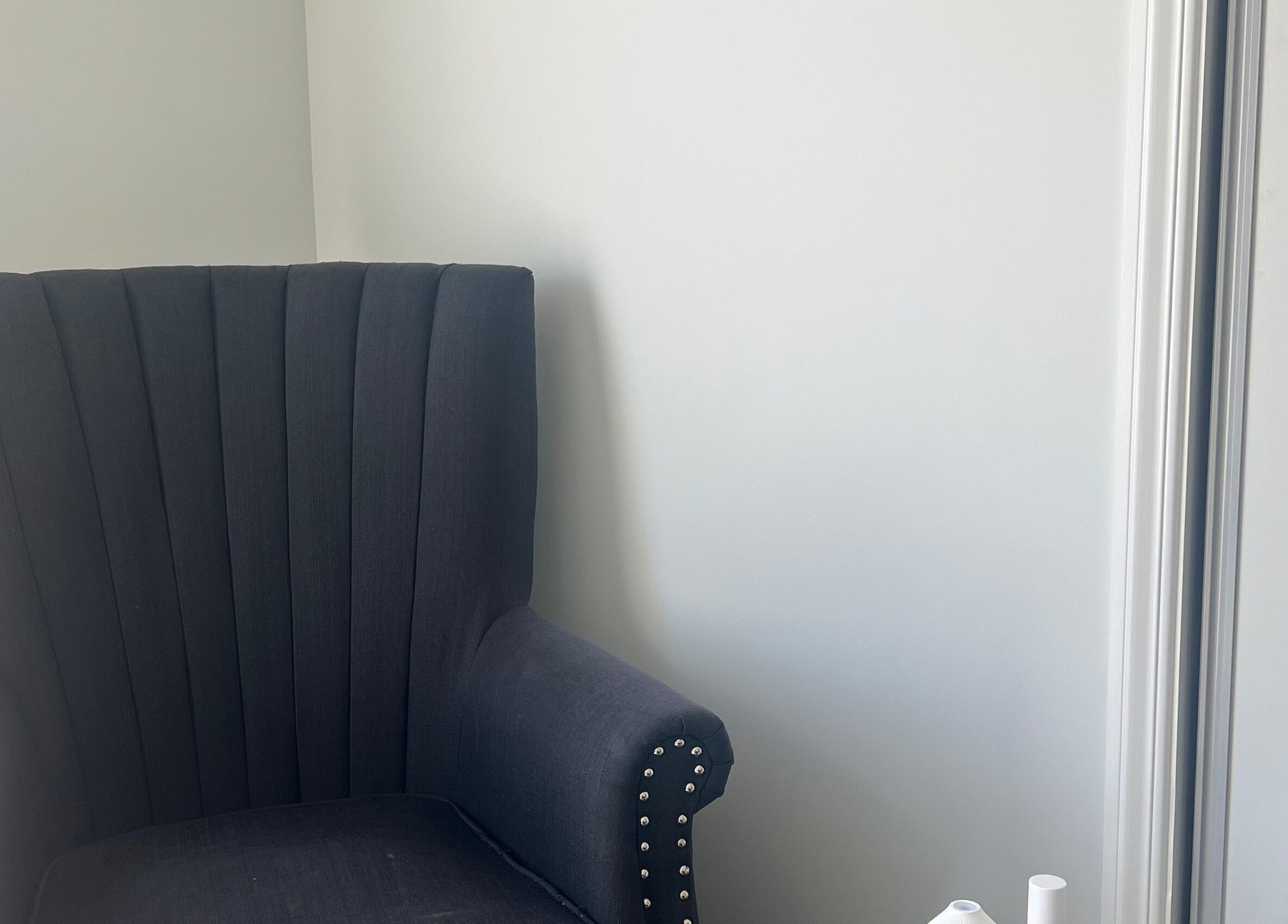 Chic grey armchair at HomeGlow Aesthetics, Christchurch, Canterbury Region, NZ offering a cozy ambience.
