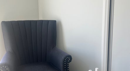 Chic grey armchair at HomeGlow Aesthetics, Christchurch, Canterbury Region, NZ offering a cozy ambience.