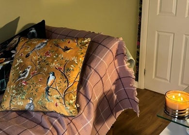 Inviting lounge at Leigh & Rose, Flitwick, England, GB with patterned cushions and a warm candlelight ambiance.