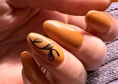 Detailed nail art design at Leigh & Rose, Flitwick, England, GB features intricate leaf pattern on orange nails.