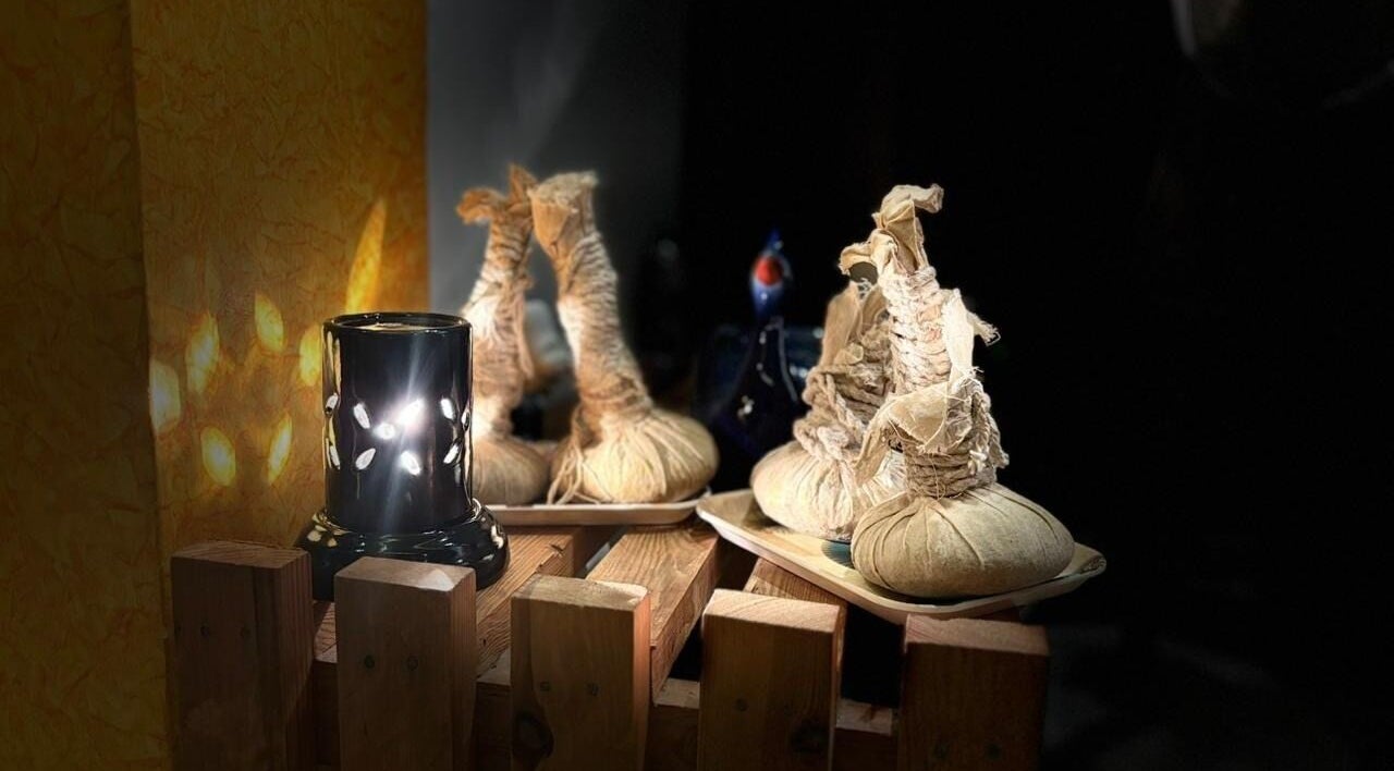 Herbal pouches and candle at Shaakya Spa & Wellness, Bengaluru, Karnataka, IN, create a calming atmosphere.