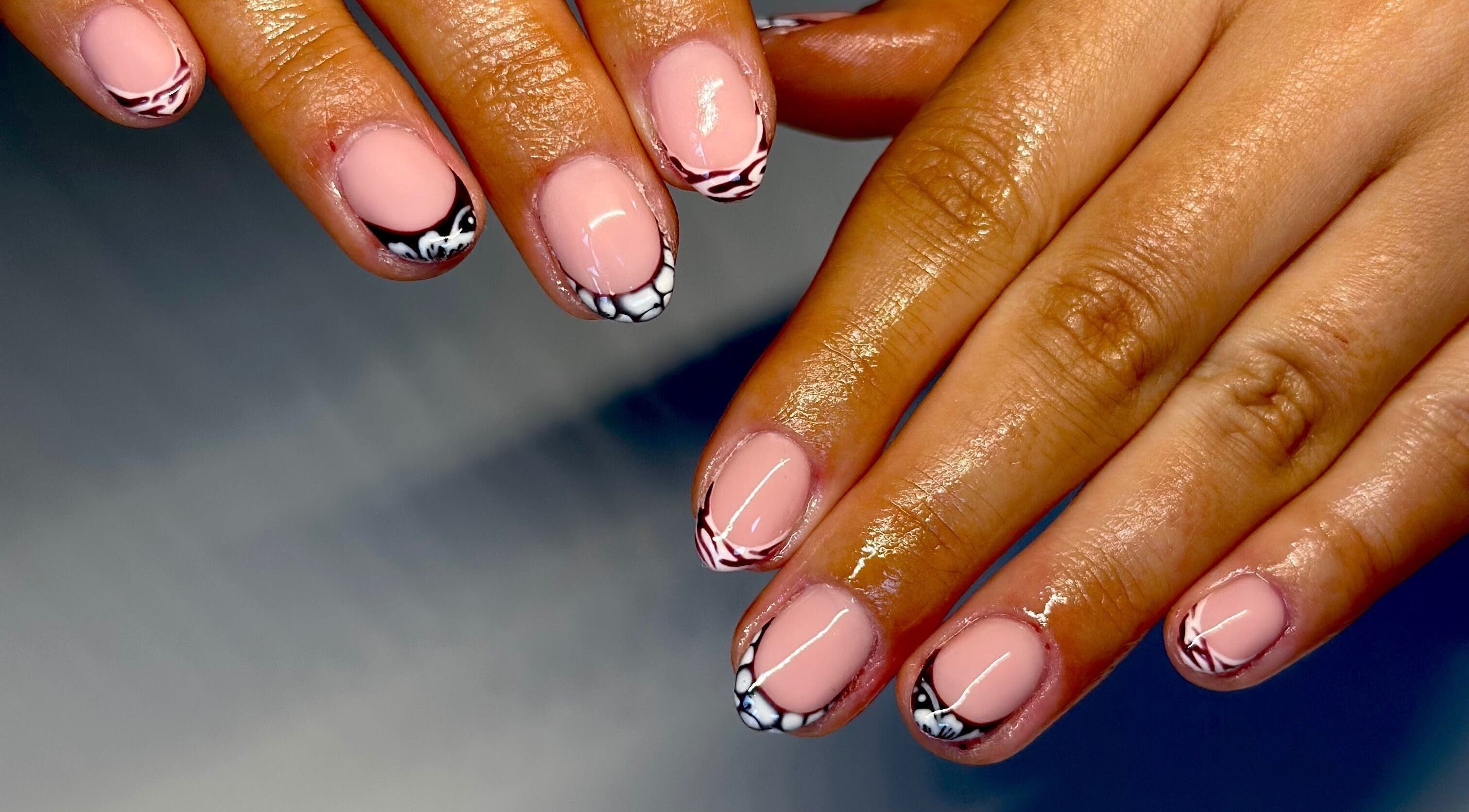 Elegant nail art design at Nails By Lauren in Crawley, England, GB, showcasing glossy pink manicure with black accents.