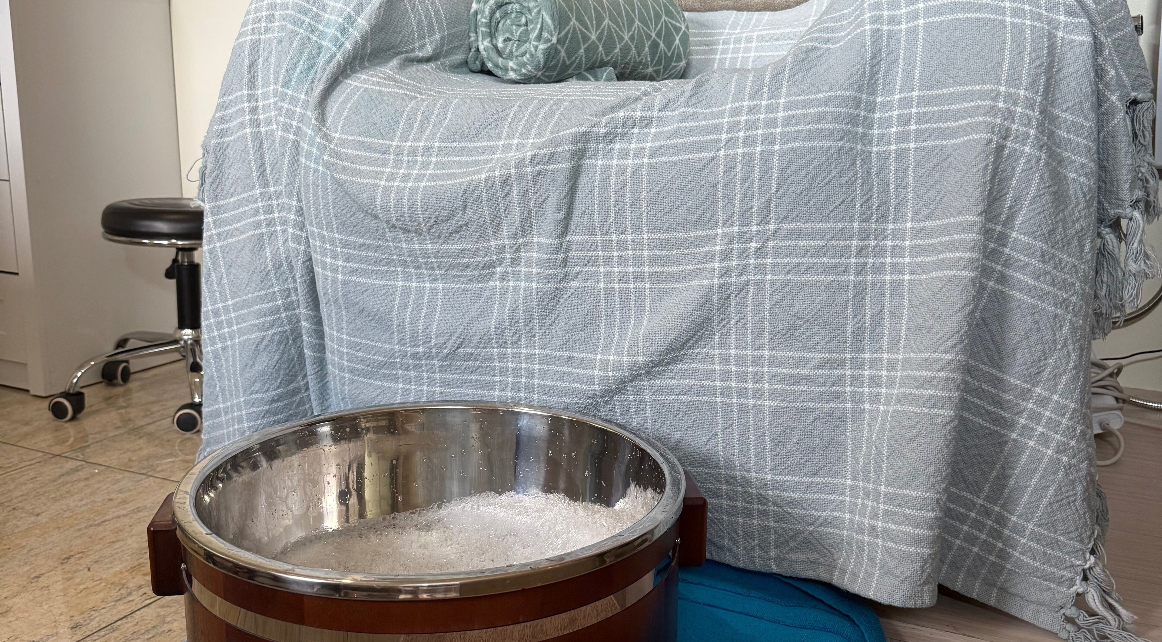 Relaxing foot soak setup at Be Still Spa, Roche Caiman, SC with a cozy blanket and patterned cushion.