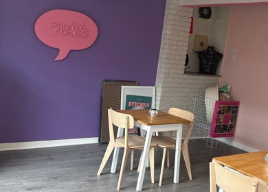 Modern seating at Canine Adventures, Seaham, England, GB, with purple and pink decor featuring Suzie's sign.