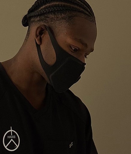 Professional at HaWB Treatment in London, England, GB, wearing a branded uniform and face mask.