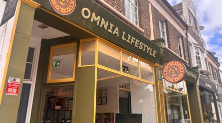 Front view of Omnia Lifestyle in London, England, GB, featuring a stylish green and yellow exterior facade.