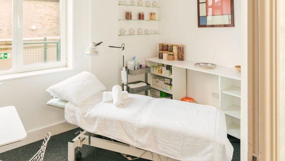 Relaxing treatment room at Omnia Lifestyle, London, England, GB featuring a bed and serene decor.