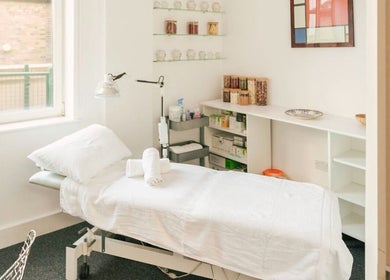 Relaxing treatment room at Omnia Lifestyle, London, England, GB featuring a bed and serene decor.