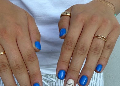Stylish blue nail art at BrauntonGels, Braunton, England, GB. Perfectly polished hands with rings.