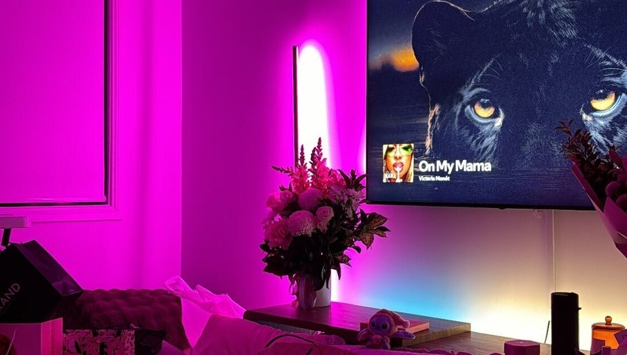 KLAWZ BY KAYLA, Maroubra: Cozy room with purple lighting, flowers, and TV ambience.