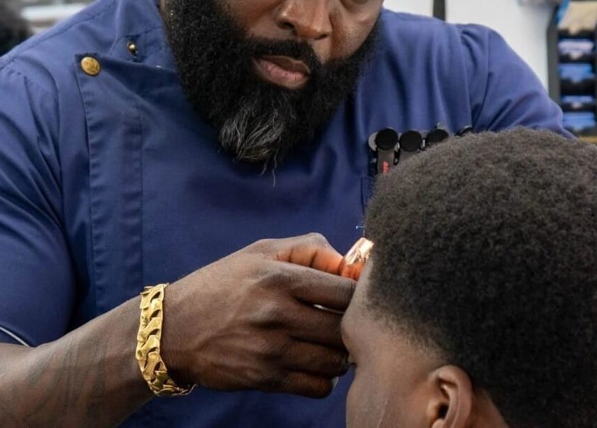 Barber at Flawlesscuts in Oshawa, Ontario, CA expertly styling a client's hair with precision.