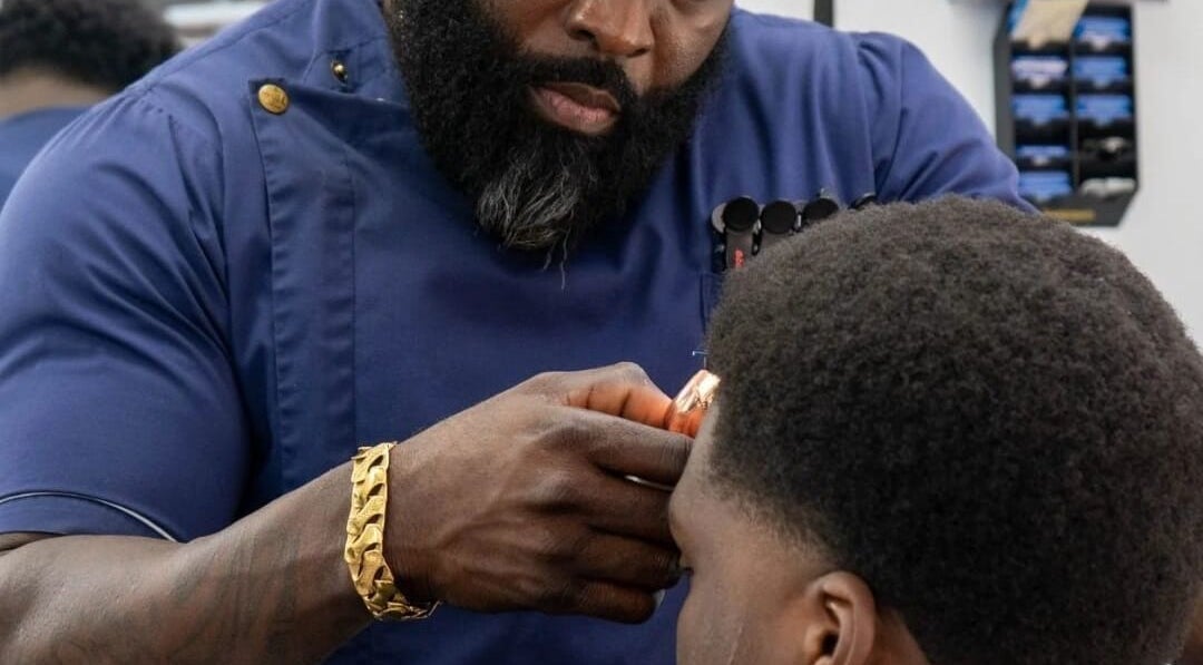 Barber at Flawlesscuts in Oshawa, Ontario, CA expertly styling a client's hair with precision.