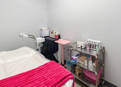 Cozy treatment room at Babe Brows Lash Lounge By Liz, Massapequa Park, New York, US with a vibrant pink blanket.