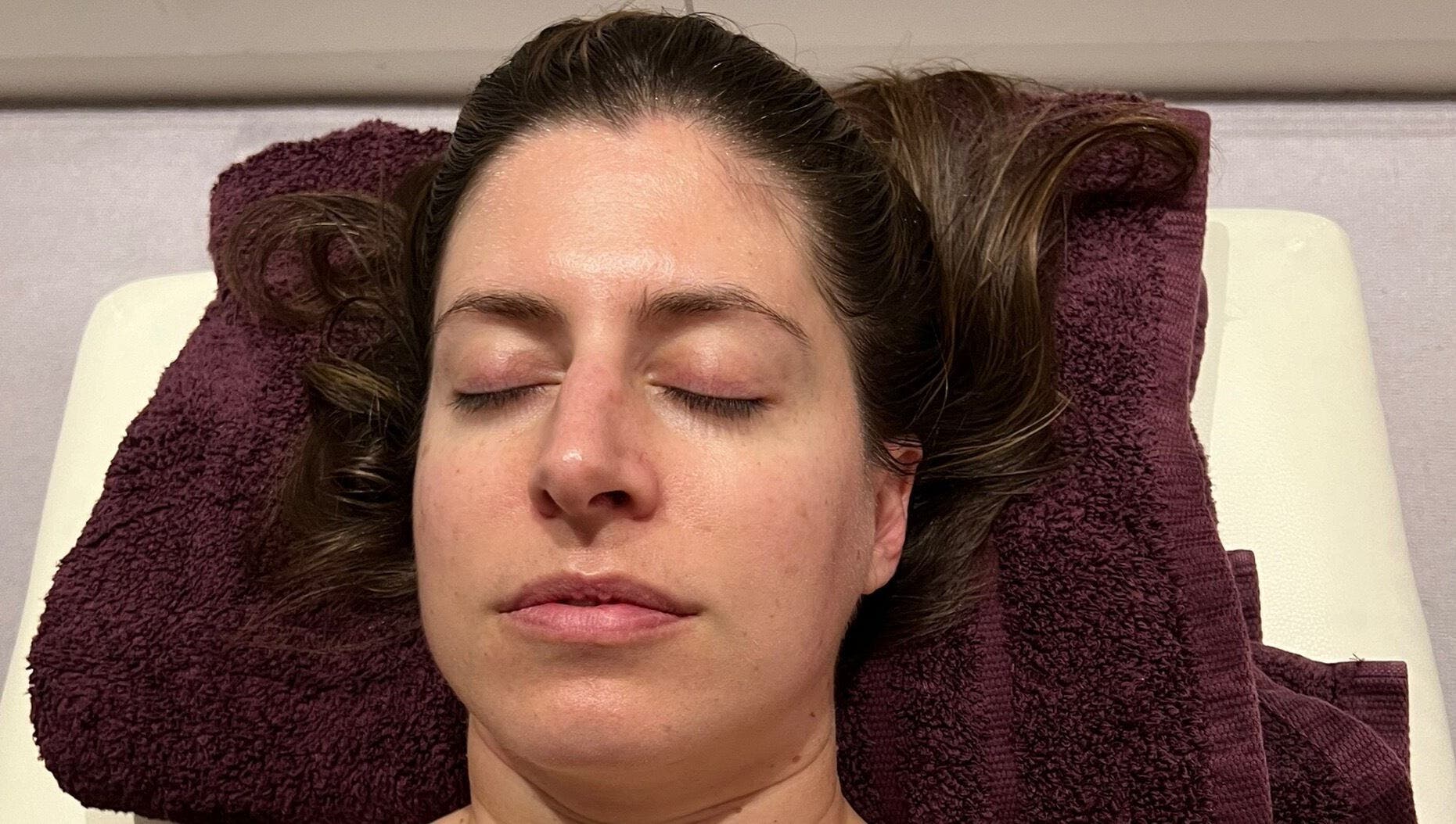 Person relaxing on plush towel at Diana Therapy, London, GB, enjoying a soothing wellness treatment.