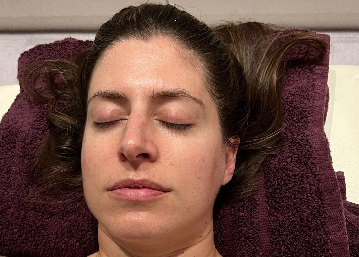 Person relaxing on plush towel at Diana Therapy, London, GB, enjoying a soothing wellness treatment.