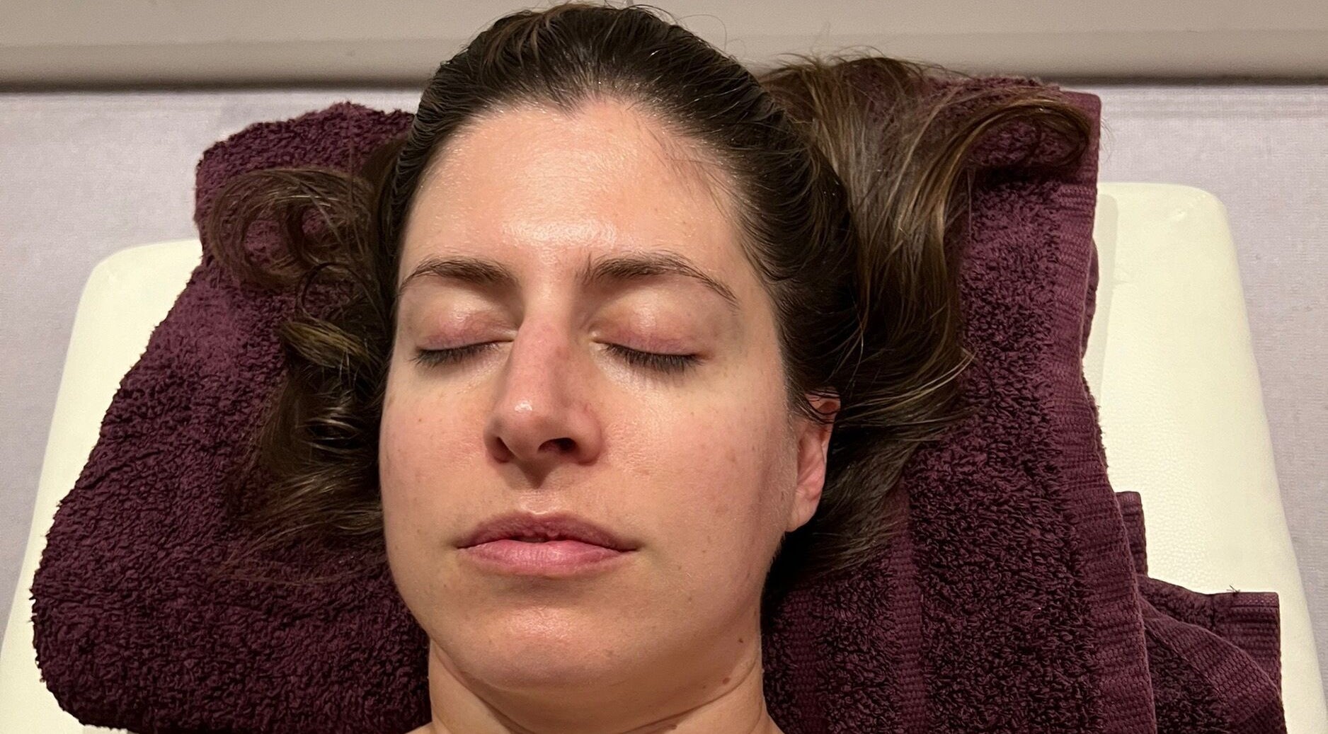 Person relaxing on plush towel at Diana Therapy, London, GB, enjoying a soothing wellness treatment.