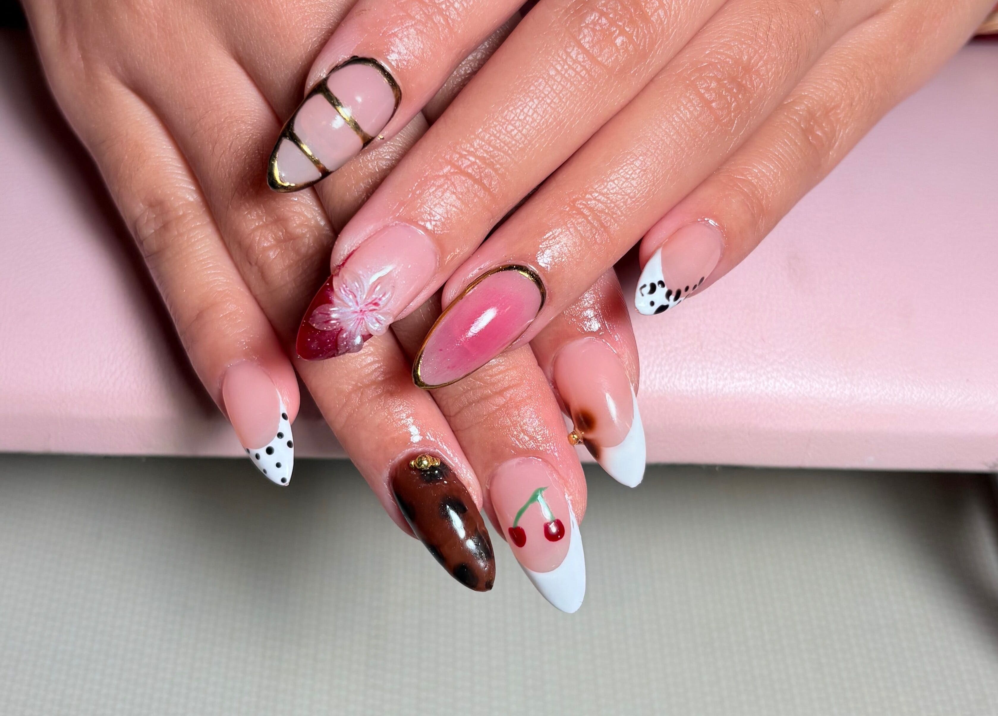 Elegant nail art at KuredKlaws in Ottawa, Ontario, CA showcases detailed designs with floral and cherry motifs.