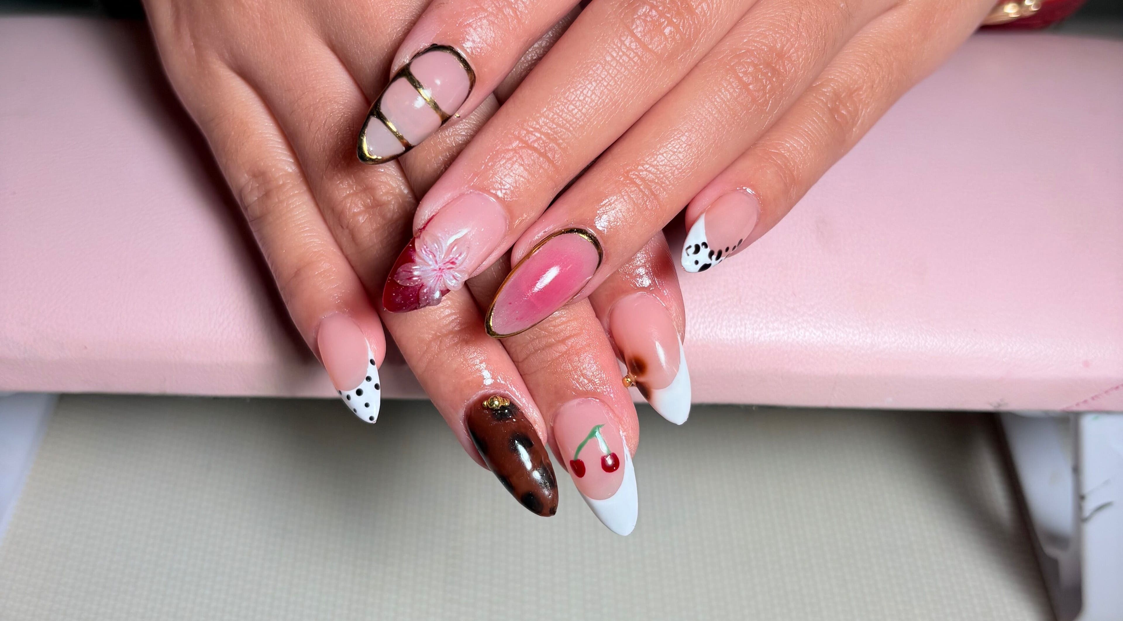 Elegant nail art at KuredKlaws in Ottawa, Ontario, CA showcases detailed designs with floral and cherry motifs.