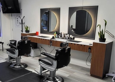 Modern barber stations at Ralston Barber Studio, Mississauga, Ontario, CA, featuring sleek chairs and mirrors.