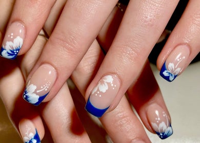 Elegant floral nail art at Nail Oasis, Pukekohe, Auckland, NZ, showcasing blue and white designs.