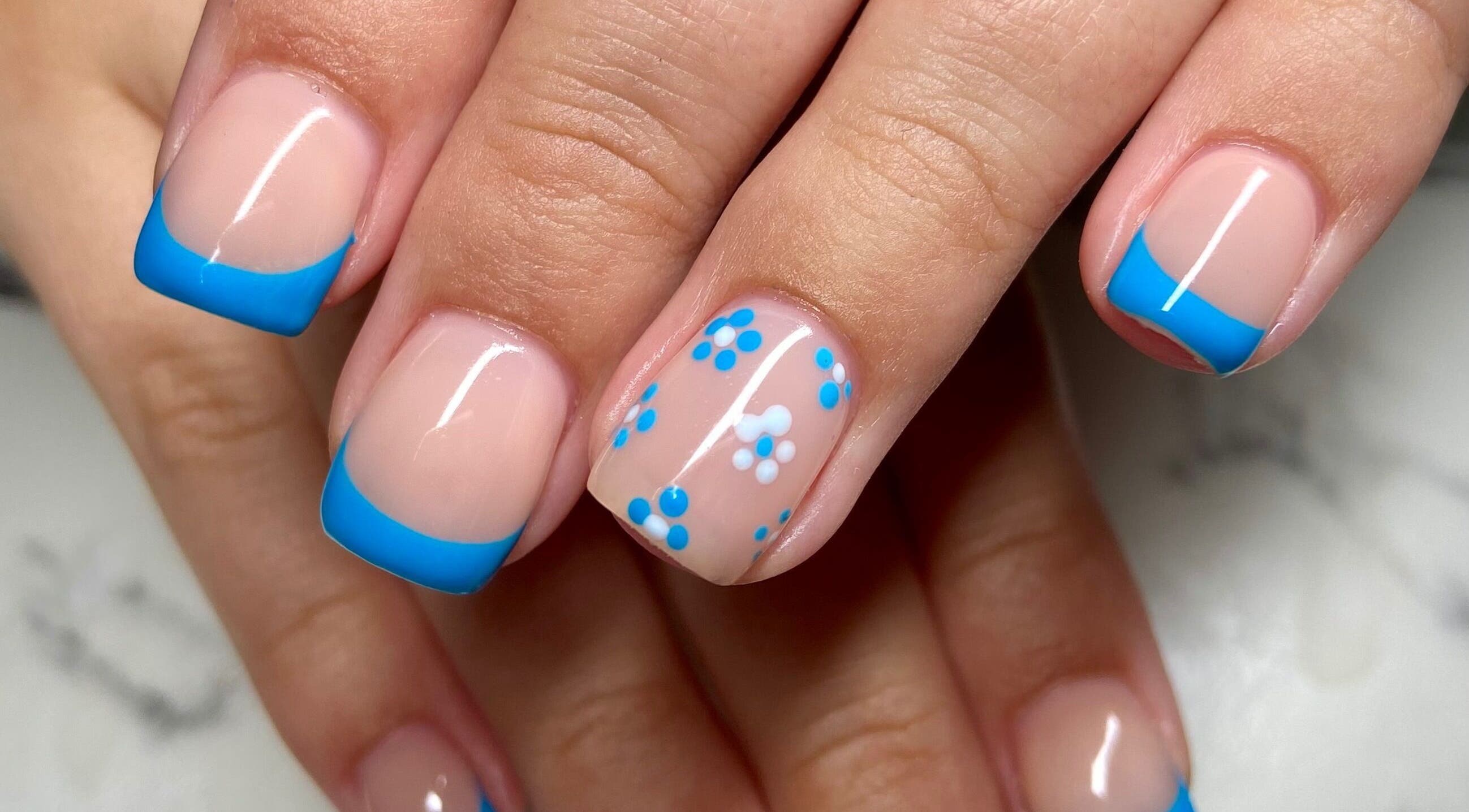 Stylish blue French tips with floral design at Nail Oasis, Pukekohe, Auckland, NZ.