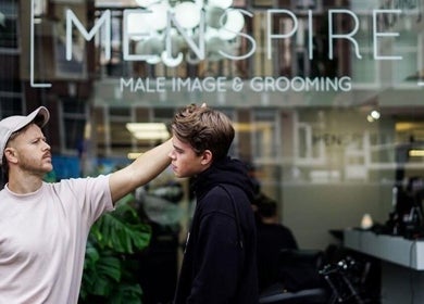 MENSPIRE Old West barber in Amsterdam providing grooming services to a client outside the venue.