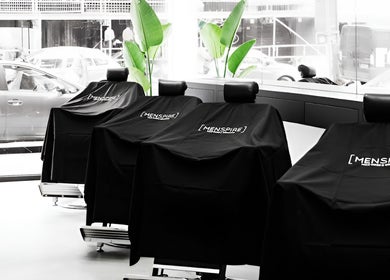 Modern barber chairs at MENSPIRE Beethoven in Amsterdam, Noord-Holland, NL with sleek black covers.