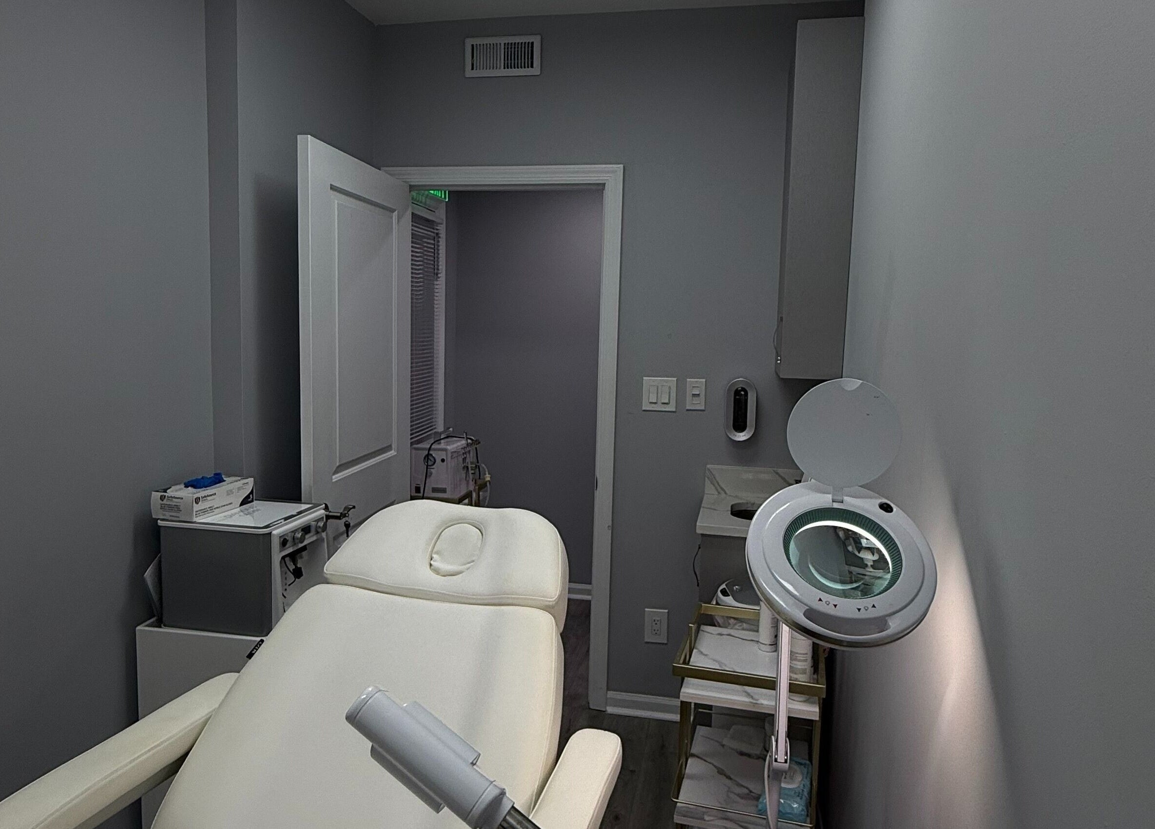 Tranquil treatment room at Injectables NYC, New York, New York, US, featuring a plush white chair and sleek decor.