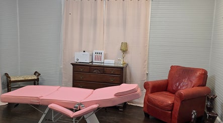 Peaceful treatment room at Worth the Rip, Blythewood, South Carolina, US, with pink table and red chair.
