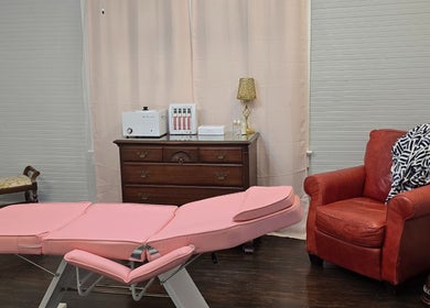 Pink treatment bed and cozy chair at Worth the Rip, Blythewood, South Carolina, US wellness center.