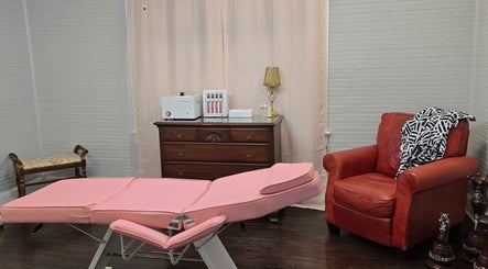 Pink treatment bed and cozy chair at Worth the Rip, Blythewood, South Carolina, US wellness center.