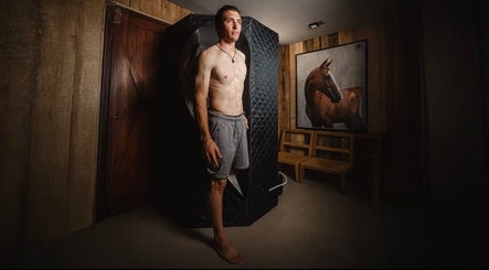 Man standing in cryotherapy chamber at Relab center, Mendoza, Mendoza, AR with horse art on wall.