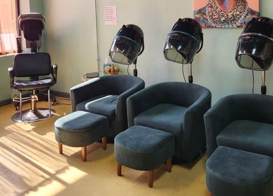 Relaxing seating area at A Different You Salon in Houston, Texas, US, featuring modern salon chairs and hair dryers.