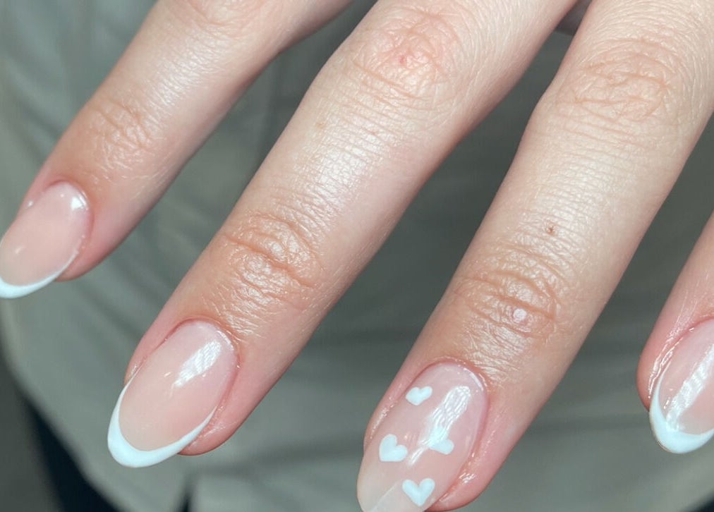 French manicure with heart design at Aura Nail Studio, Fairy Meadow, New South Wales, AU.