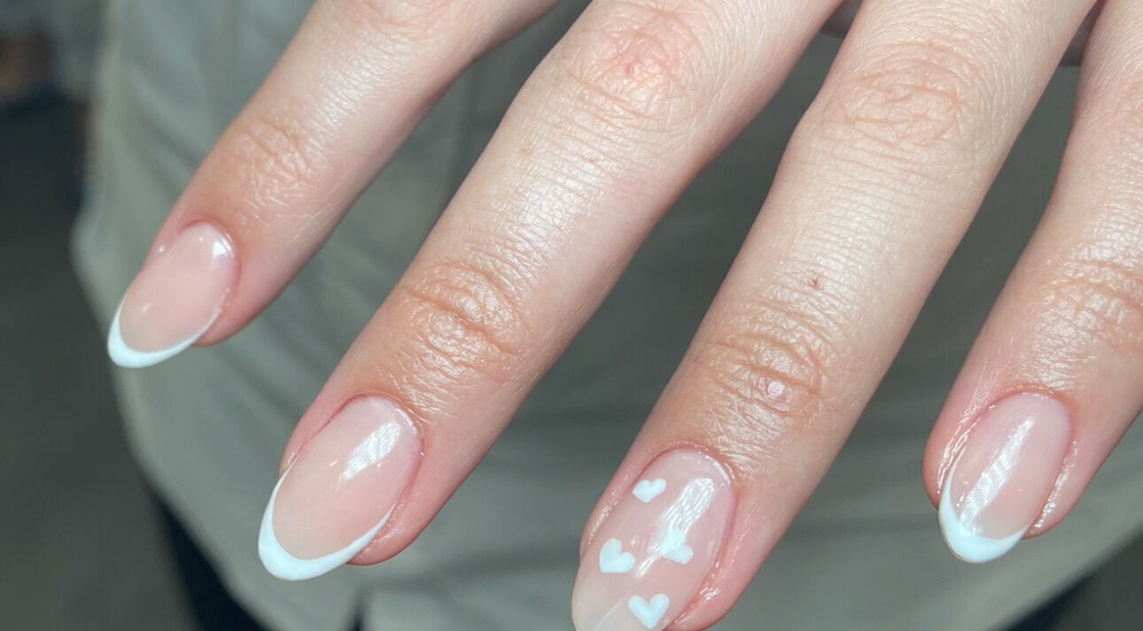 French manicure with heart design at Aura Nail Studio, Fairy Meadow, New South Wales, AU.