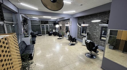 Modern interior of La Barbería at Tres Ríos centro, San José, CR, showcasing sleek barber chairs and stylish decor.