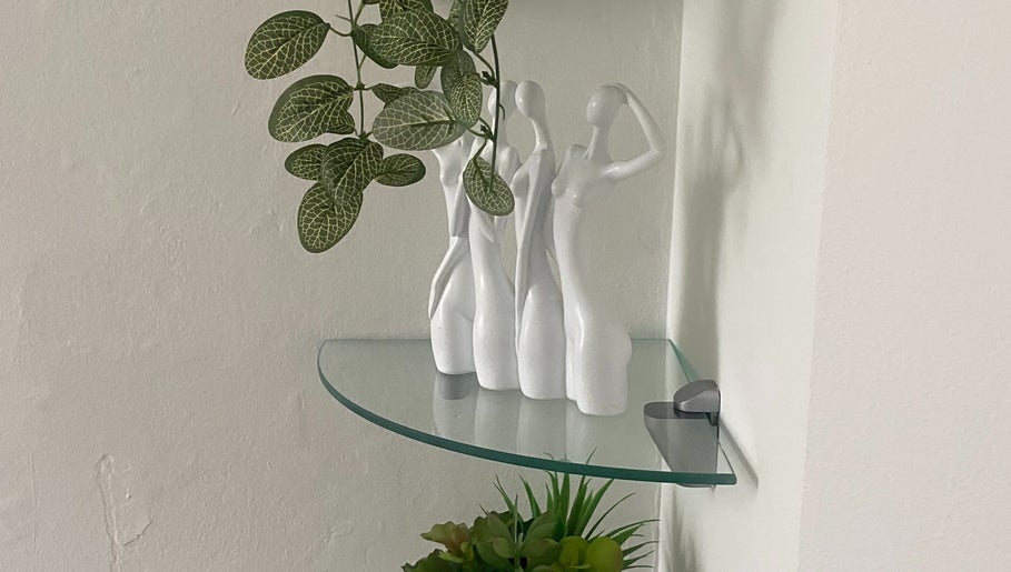 Elegant statuettes and plants on glass shelf at Hude, Royal Tunbridge Wells, England, GB.