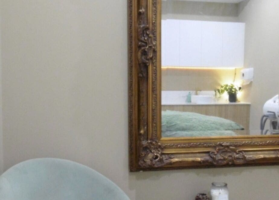 An ornate mirror and cozy chair at Timeless Aesthetics in Karnup, Western Australia, AU.