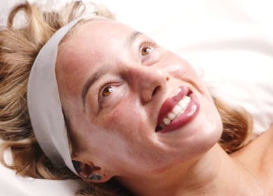 Smiling woman enjoying a facial at The Skin Theory, Lichfield, England, GB, showcasing radiant skin.