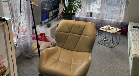 Уютный интерьер Airtouchmenow, Вустер, Англия, GB, с кожаным креслом и столиком с косметикой.