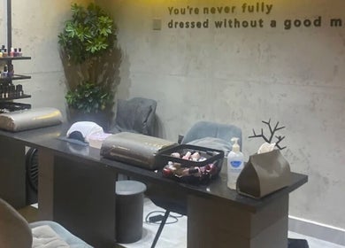 Modern manicure station at 5ive Seconds Salon - Al Raed, Riyadh, Riyadh Province, SA, with polishes and greenery.