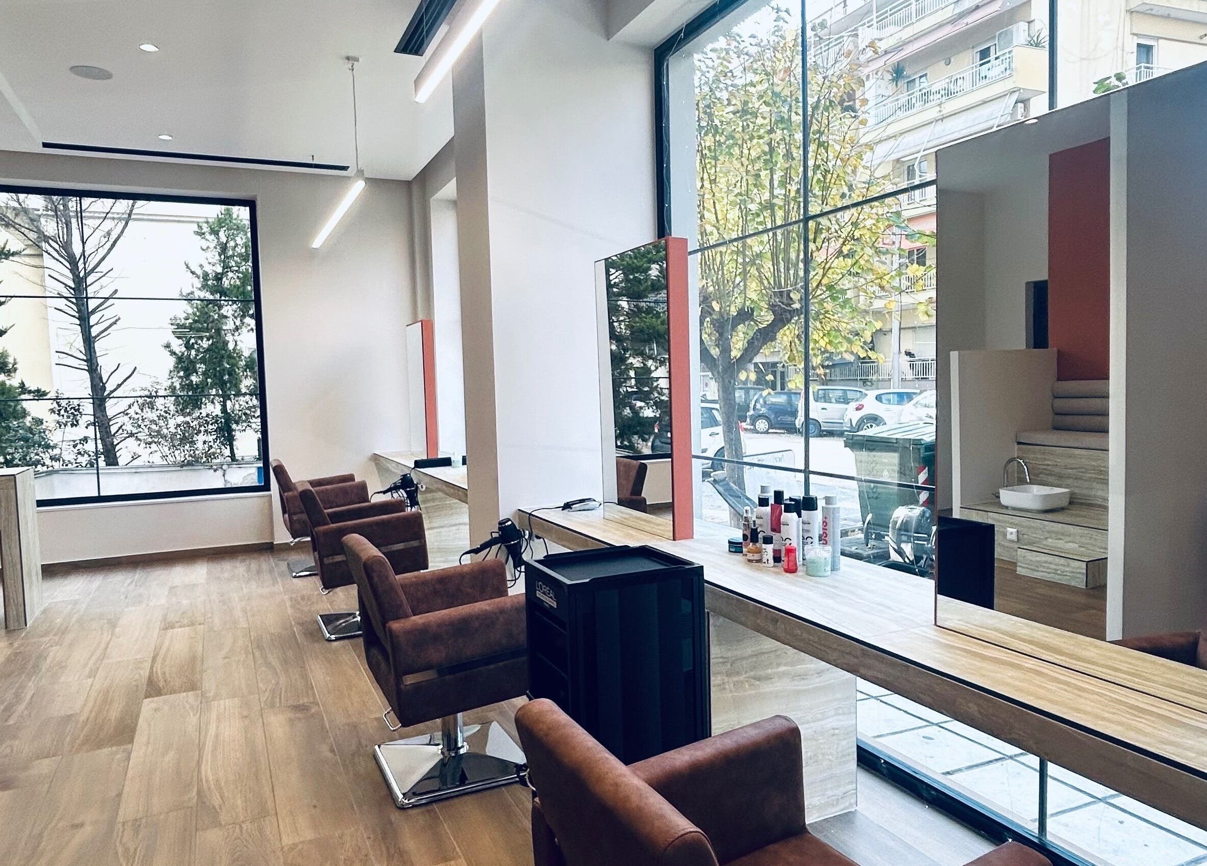 Εσωτερικός χώρος του ELYSIA TOUCH στη Θεσσαλονίκη, GR με καρέκλες κομμωτηρίου δίπλα σε μεγάλα παράθυρα.